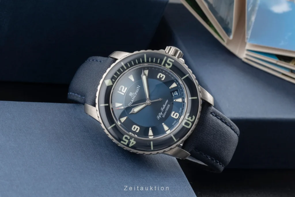 Blancpain Fifty Fathoms : montre de plongée en titane avec cadran bleu, lunette unidirectionnelle et bracelet textile, mise en scène élégante en gros plan