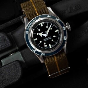 marque Serica montre 5303-PLD avec lunette de plongée bleue et bracelet NATO, mise en scène sur du matériel technique.